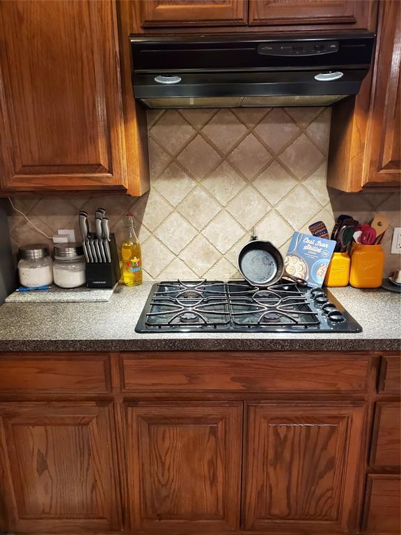 kitchen with black gas stovetop and decorative backsplash