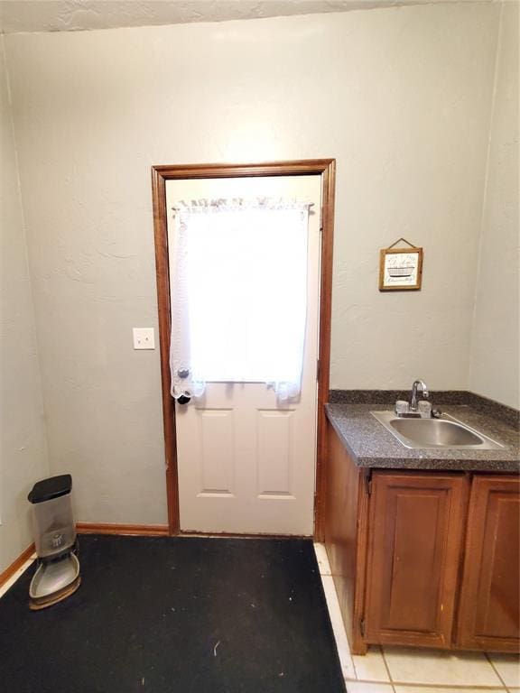 doorway to outside with sink and light tile patterned floors