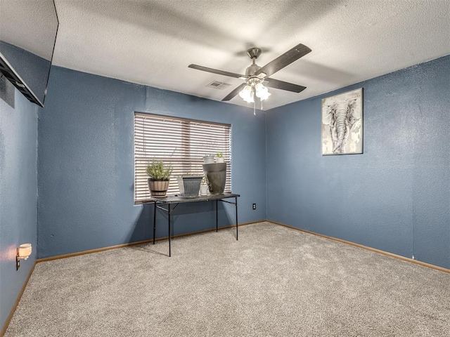 carpeted empty room with a textured ceiling and ceiling fan