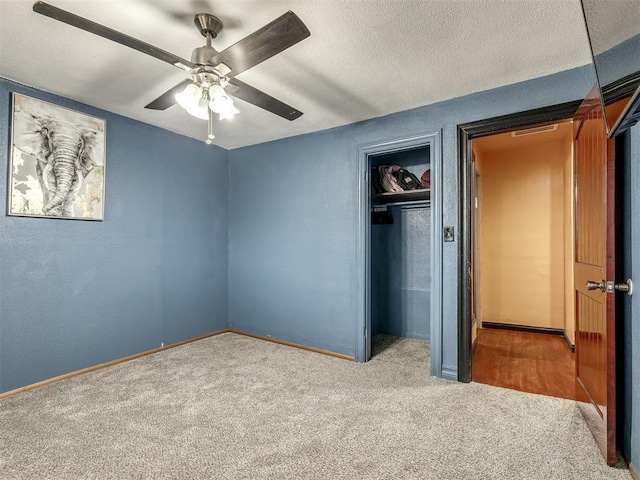 unfurnished bedroom featuring ceiling fan, carpet, a textured ceiling, and a closet