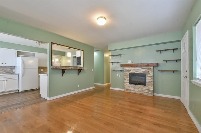 unfurnished living room featuring a fireplace and light hardwood / wood-style flooring