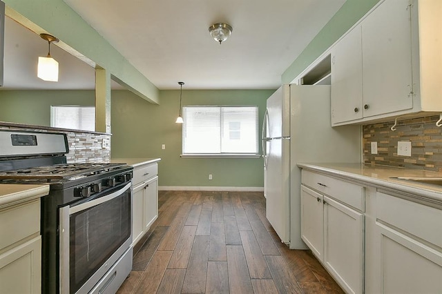 kitchen featuring white cabinets, hanging light fixtures, and stainless steel gas range oven