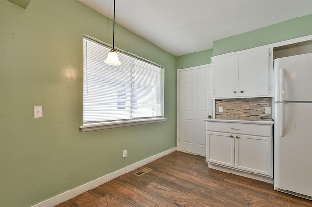 kitchen with white refrigerator, white cabinets, dark hardwood / wood-style floors, and pendant lighting