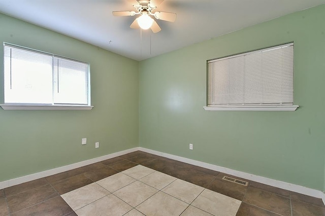 tiled spare room with ceiling fan