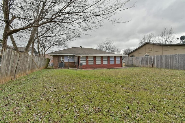 rear view of house featuring a yard