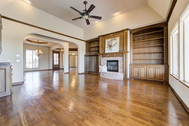 unfurnished living room with ceiling fan, hardwood / wood-style floors, a brick fireplace, and built in features