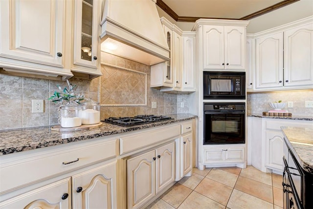 kitchen featuring premium range hood, tasteful backsplash, light tile patterned floors, light stone countertops, and black appliances