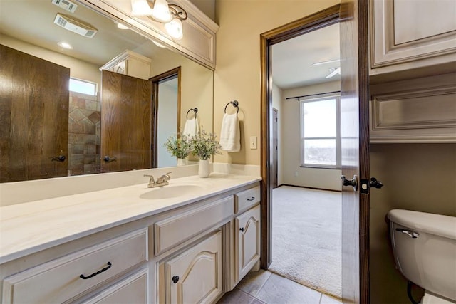 bathroom with tile patterned flooring, vanity, and toilet