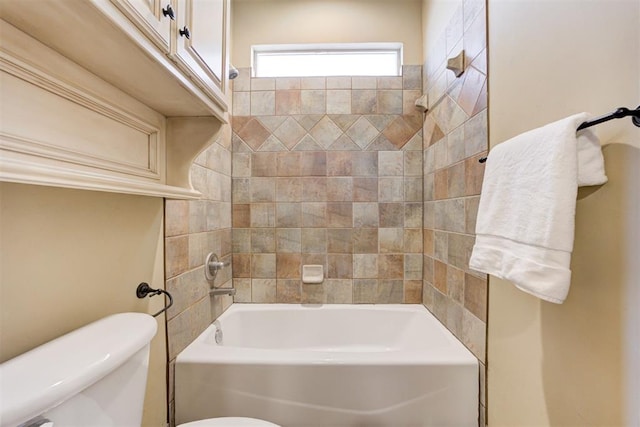 bathroom with tiled shower / bath combo and toilet