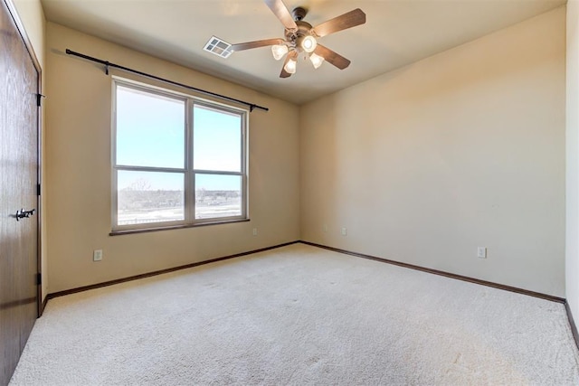 carpeted spare room with ceiling fan