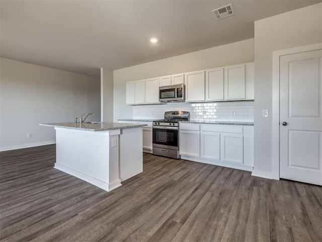 13136 Mannington Rd, Edmond, OK 73025 - kitchen with stainless steel appliances, dark wood finished floors, tasteful backsplash, a sink, and white cabinets