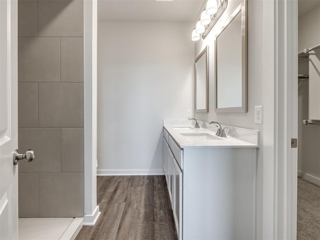 13136 Mannington Rd, Edmond, OK 73025 - full bath with baseboards, a tile shower, double vanity, wood finished floors, and a spacious closet