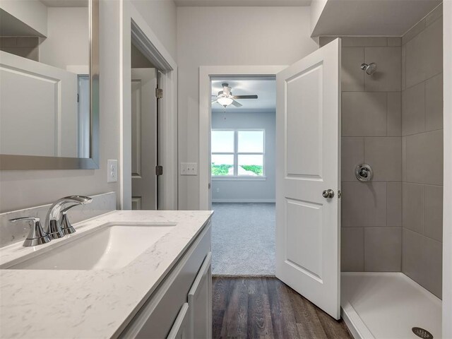 13136 Mannington Rd, Edmond, OK 73025 - bathroom with ceiling fan, tiled shower, wood finished floors, and vanity