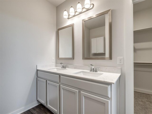 13136 Mannington Rd, Edmond, OK 73025 - full bathroom with double vanity, baseboards, and a spacious closet