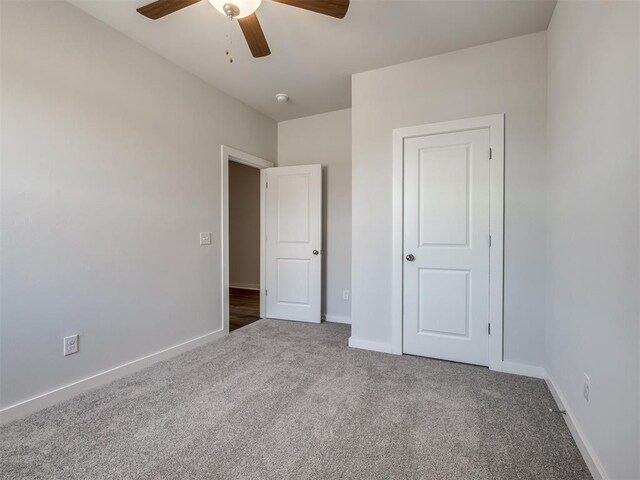 13136 Mannington Rd, Edmond, OK 73025 - unfurnished bedroom featuring carpet floors, baseboards, and a ceiling fan