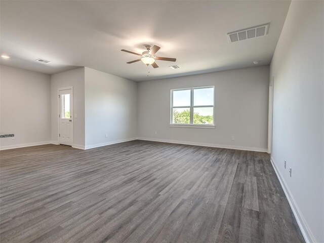 13136 Mannington Rd, Edmond, OK 73025 - empty room with plenty of natural light, dark wood-style flooring, a ceiling fan, and baseboards