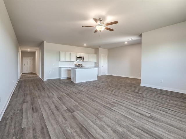 13136 Mannington Rd, Edmond, OK 73025 - unfurnished living room with ceiling fan, dark wood-type flooring, baseboards, and recessed lighting