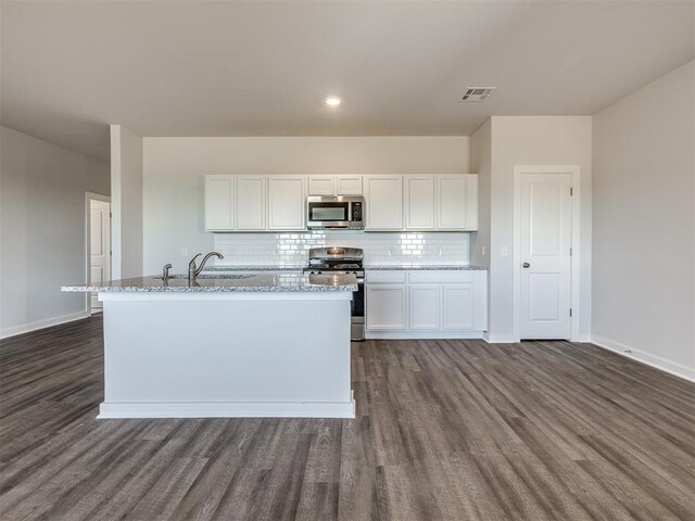 13136 Mannington Rd, Edmond, OK 73025 - kitchen with appliances with stainless steel finishes, a sink, dark wood finished floors, light stone countertops, and white cabinets