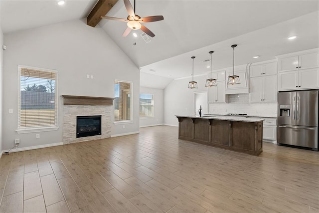 kitchen featuring visible vents, ceiling fan, stainless steel fridge with ice dispenser, open floor plan, and light wood-style flooring