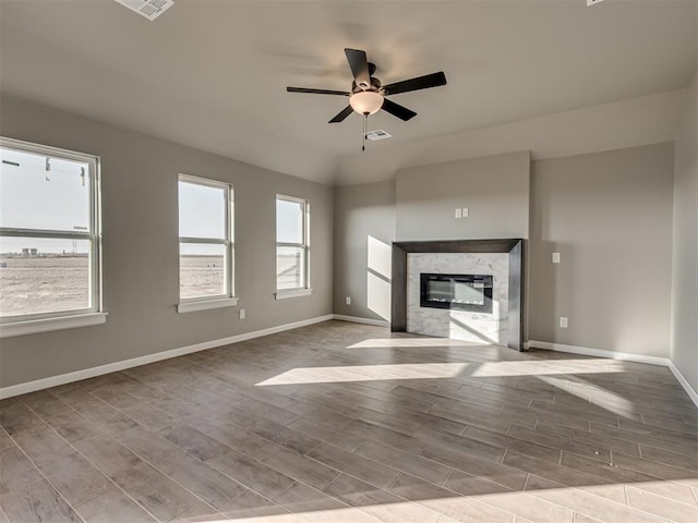 unfurnished living room featuring ceiling fan and a high end fireplace