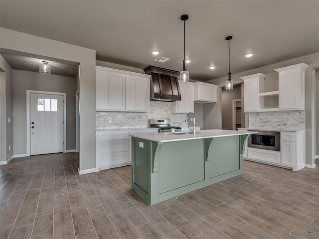 kitchen featuring white cabinetry, stainless steel stove, custom exhaust hood, and built in microwave