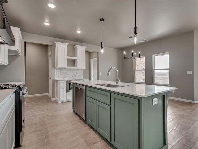 kitchen with sink, green cabinets, stove, an island with sink, and white cabinets