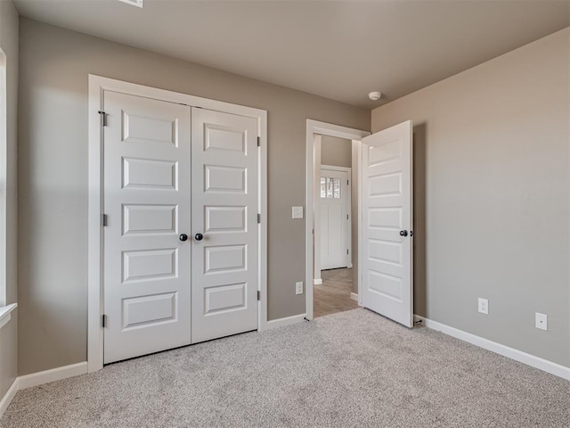 unfurnished bedroom featuring light colored carpet and a closet