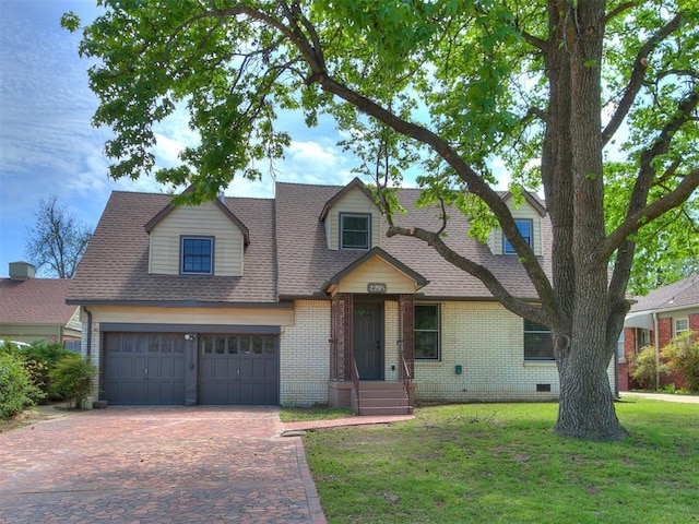 cape cod home with crawl space, roof with shingles, brick siding, decorative driveway, and a front lawn