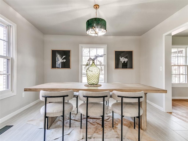 dining room with visible vents, a healthy amount of sunlight, and light wood-type flooring
