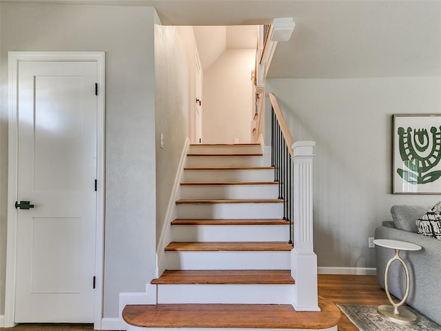 staircase with baseboards and wood finished floors