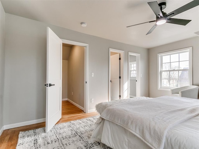 bedroom featuring baseboards, ceiling fan, and wood finished floors