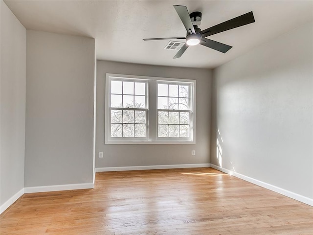 empty room with a ceiling fan, baseboards, visible vents, and light wood finished floors