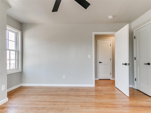 empty room with a ceiling fan, baseboards, and light wood-style flooring