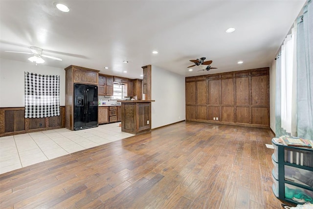 unfurnished living room featuring ceiling fan and light hardwood / wood-style floors