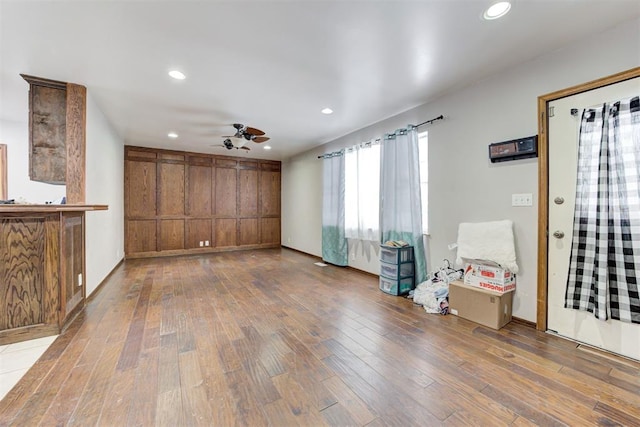 unfurnished living room with wood-type flooring and ceiling fan