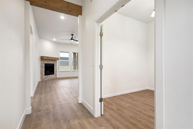 corridor with beamed ceiling and light hardwood / wood-style floors