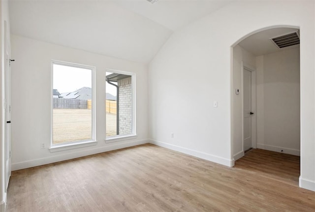 empty room featuring vaulted ceiling and light hardwood / wood-style floors