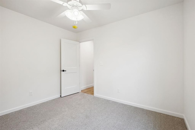 spare room featuring light carpet and ceiling fan