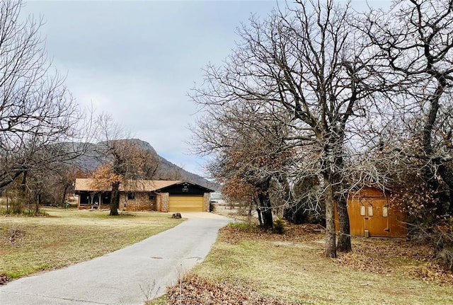 exterior space featuring a garage, a mountain view, and a front lawn