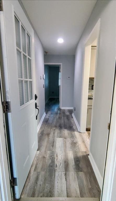 hall featuring recessed lighting, baseboards, and wood finished floors