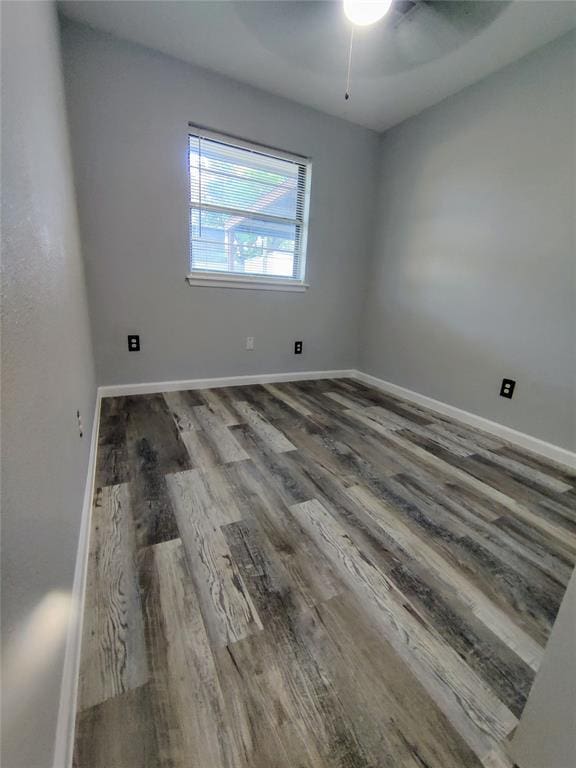spare room featuring a ceiling fan, baseboards, and wood finished floors