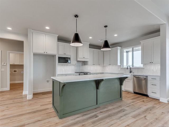 6209 Rivergate Dr, Shawnee, OK 74804 - kitchen featuring a kitchen island, decorative light fixtures, built in microwave, white cabinets, and stainless steel dishwasher