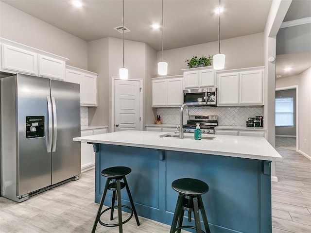 kitchen featuring pendant lighting, white cabinetry, and appliances with stainless steel finishes