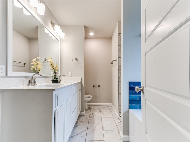 bathroom with vanity, a tub to relax in, and toilet