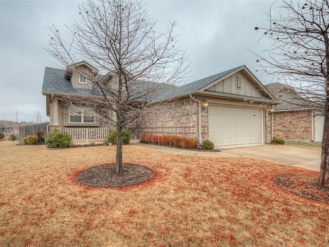 view of front of home featuring a garage, a front yard, and covered porch