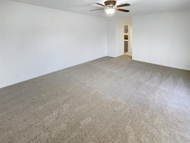 spare room featuring ceiling fan and carpet floors