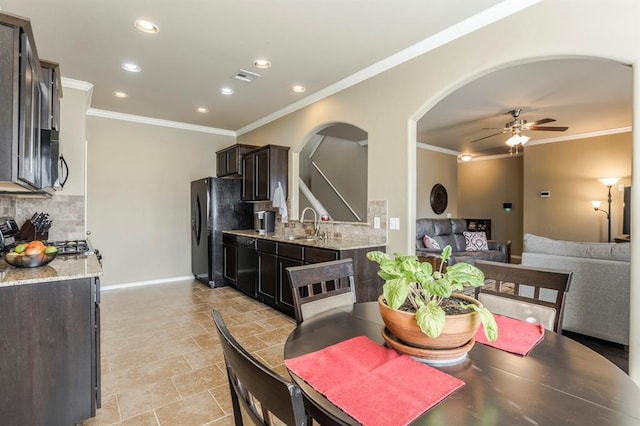 dining room with crown molding, ceiling fan, and sink