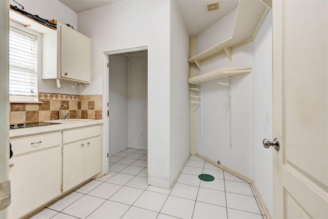 kitchen featuring light tile patterned floors, decorative backsplash, and sink