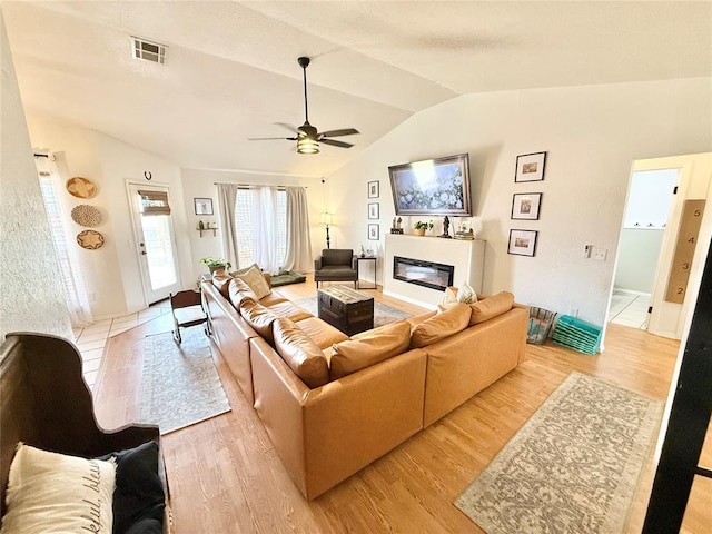 living room featuring lofted ceiling, light hardwood / wood-style flooring, and ceiling fan