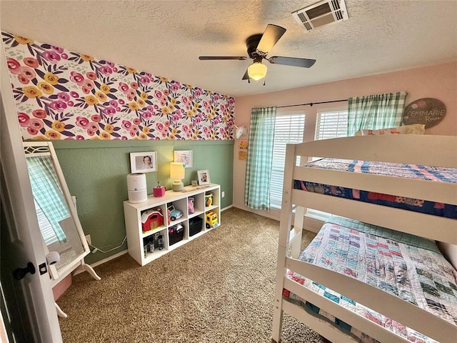 carpeted bedroom with ceiling fan and a textured ceiling